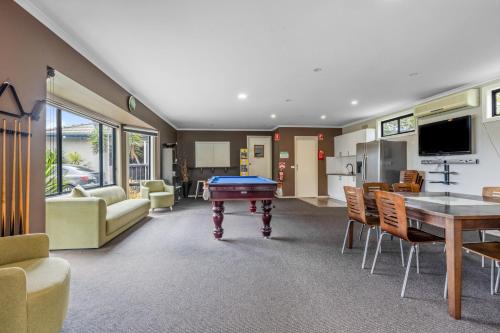 a living room with a pool table and a kitchen at Rosebud Motel in Tootgarook