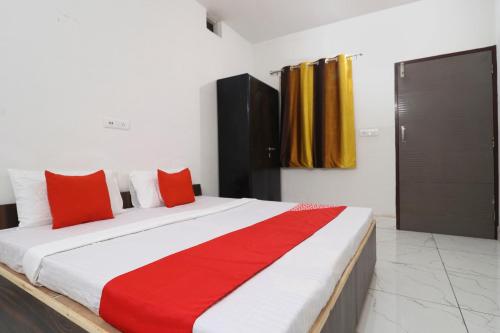 1 dormitorio con 1 cama grande con almohadas rojas en OYO Hotel Sky Garden en Ludhiana