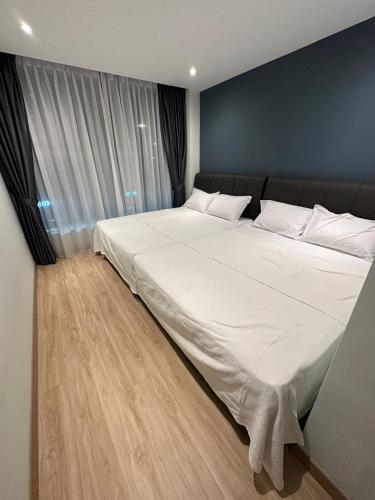 a large white bed in a bedroom with a blue wall at CT HOME83Stay - Klebang Beach Melaka in Kelebang Besar