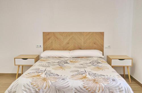 een slaapkamer met een bed met 2 nachtkastjes bij Chalet Nati in Chiclana de la Frontera