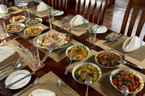 a wooden table with plates of food on it at Jetwing Hoffmann Bungalow in Welimada