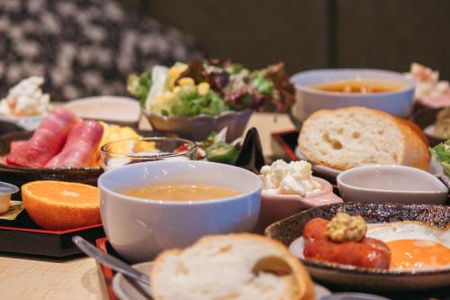 a table with plates of food and bowls of soup at Cococious Monpa in Chatan