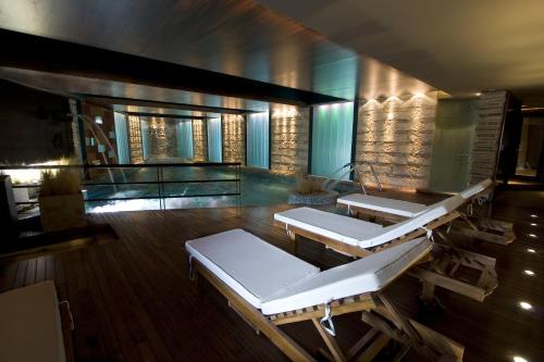 a hotel room with a pool and chairs at Imago Hotel & Spa in El Calafate