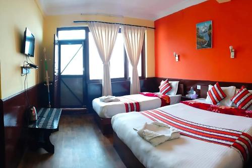 a hotel room with two beds with red walls at Mountain Resort in Nagarkot