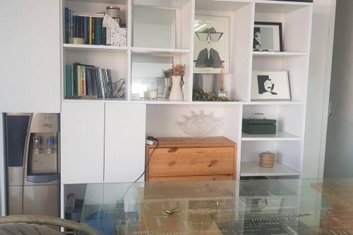 a white book shelf with a wooden drawer in a room at High By The Beach House in Girne in Ayyorgi