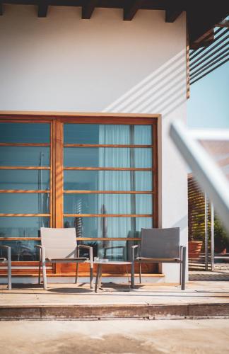 two chairs and a table in front of a building at Tre Merli Beach Hotel in Trieste