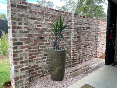 a potted plant in front of a brick wall at Simala Retreat in Cowaramup