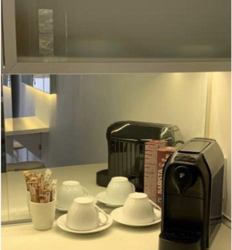 a kitchen counter with a toaster and saucers and a coffee maker at studio in vila- natural 22 C ! in Breaza de Sus