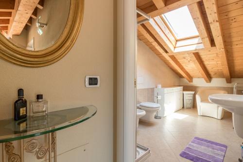 W łazience znajduje się lustro, umywalka i toaleta. w obiekcie Apartment Best - Tremezzina w mieście Tremezzo