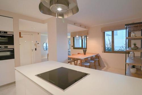une cuisine avec un comptoir blanc et une table dans l'établissement GRAY Renovated luxurious apartment located in Cannes, à Cannes