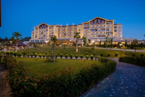 a large building with a park in front of it at BN Hotel Thermal & Wellness in Mersin
