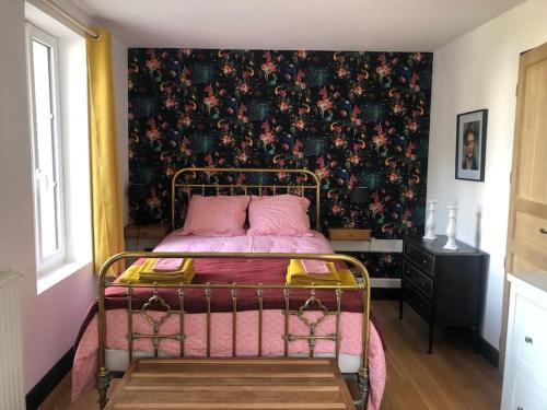 - une chambre avec un lit et un papier peint floral dans l'établissement LE CHARMANT COLIBRI ÉTRETAT, à Étretat