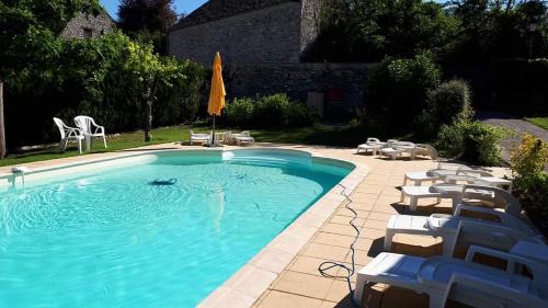 una gran piscina con sillas y sombrilla en Au Chat Perché espace familial, en Mareil-sur-Mauldre