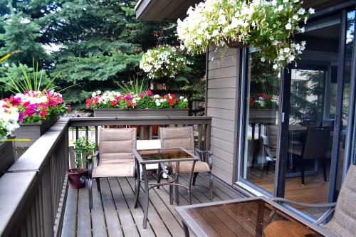 a deck with chairs and a table and flowers at A Good Nite's Rest Bed and Breakfast in Banff