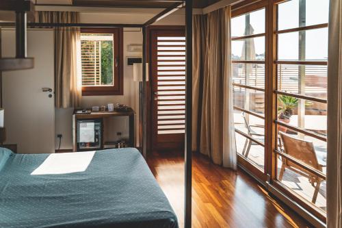 a bedroom with a bed and a large window at Tre Merli Beach Hotel in Trieste