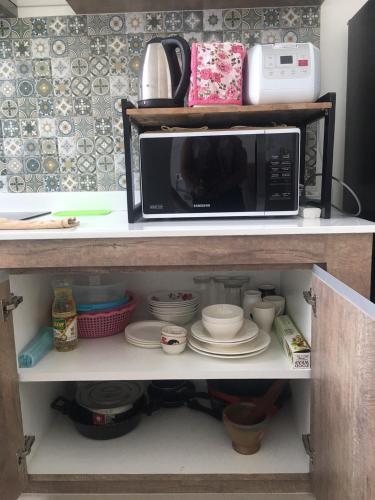 a microwave oven sitting on top of a shelf at The Midst by The M - Nakhon Nayok TMD4 in Ban Som Phung Haeng (1)
