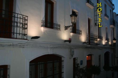 a white building with a sign on the side of it at Hotel Castilla in Cáceres