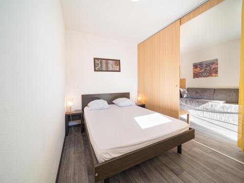 1 dormitorio con cama y espejo en Chalets du Verdon - 3401 - Appart proche pistes -, en Allos