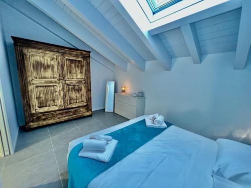 een slaapkamer met een blauw bed en handdoeken bij Prestigioso attico a passo Duomo by Revenue House in Casale Monferrato