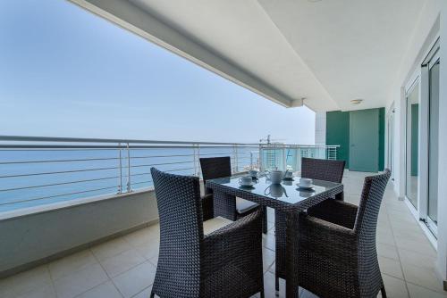 a balcony with a table and chairs on a balcony at Seafront Luxury Apartment with Pool by Buena Vista in Sliema
