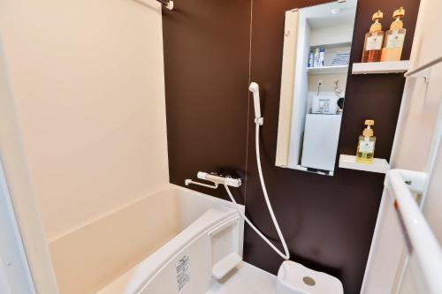 a bathroom with a bath tub and a sink at TC house/日本橋すぐ/黒門市場徒歩2分/難波・道頓堀徒歩圏内/関西エリアアクセス便利 in Osaka