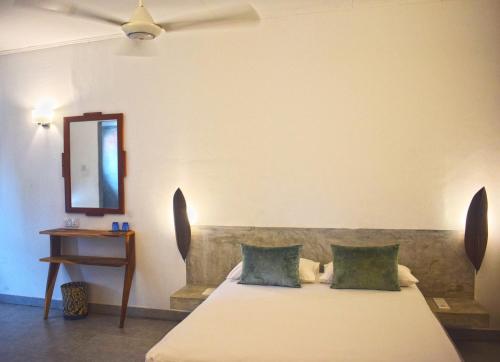 a bedroom with a bed with two pillows and a mirror at City Beds Colombo in Colombo