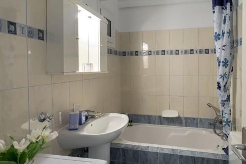 a bathroom with a sink and a bath tub at Panos Apartment in Kefallonia