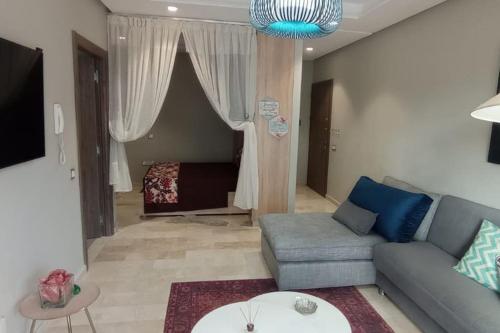 ein Wohnzimmer mit einem Sofa und einem Bett in der Unterkunft Charmant studio lumineux Casablanca in Bouskoura