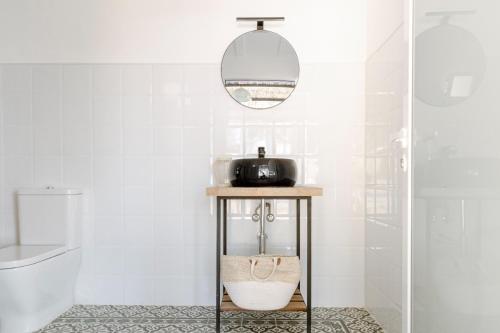 a bathroom with a table with a mirror and a toilet at Finca de l’Anglés. Levante in Potríes