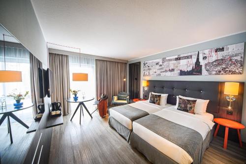 a hotel room with a bed and a television at Holiday Inn Lübeck by IHG in Lübeck