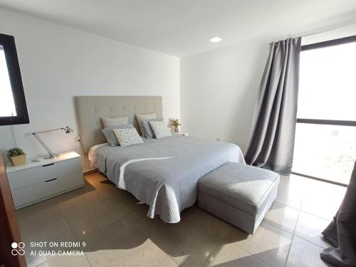 biała sypialnia z łóżkiem i oknem w obiekcie Villa Gehidy w mieście Teguise