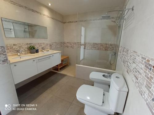 a bathroom with a toilet and a shower and a sink at Villa Gehidy in Teguise