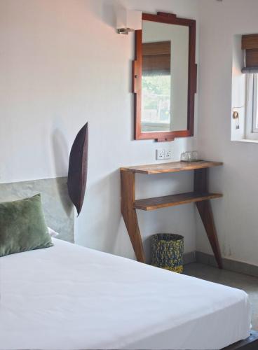 a bedroom with a bed and a mirror and a sink at City Beds Colombo in Colombo