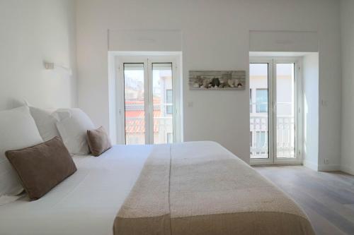 une chambre blanche avec un grand lit et deux fenêtres dans l'établissement NAPOLEON Luxurious renovated apartment 1min from Palais, à Cannes