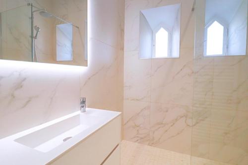 une salle de bain blanche avec une baignoire et un lavabo dans l'établissement NAPOLEON Luxurious renovated apartment 1min from Palais, à Cannes