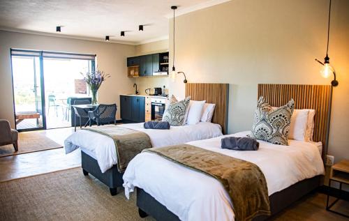 a hotel room with two beds and a kitchen at Oudewerfskloof Olive Farm in Stilbaai