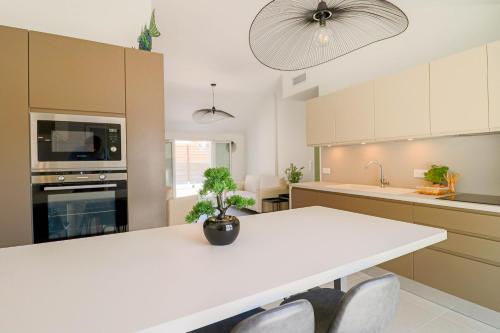 une cuisine avec une grande table blanche et des chaises dans l'établissement MEYNADIER Renovated designer apartment with rooftop in Cannes, à Cannes