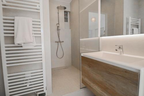 une salle de bain blanche avec un lavabo et une douche dans l'établissement MEYNADIER Renovated designer apartment with rooftop in Cannes, à Cannes