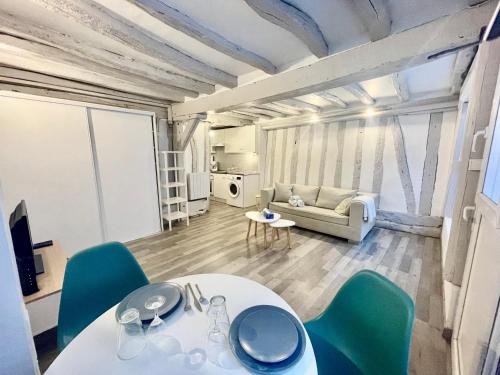 un salon avec une table, des chaises et un canapé dans l'établissement petit studio près du centre - 186, à Rouen