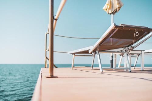 a bench on the deck of a boat at Tre Merli Beach Hotel in Trieste