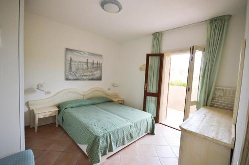 sypialnia z łóżkiem i przesuwnymi szklanymi drzwiami w obiekcie L316 - Porto Mannu villino a schiera vista mare w mieście Palau