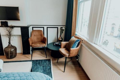 - un salon avec deux chaises, une table et une fenêtre dans l'établissement Haarlemmerstraat Central Studio, à Amsterdam