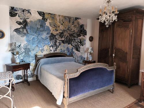 a bedroom with a bed with a floral wallpaper at Les Hortensias - Chambres d'hôtes in Saint-Antoine-de-Breuilh