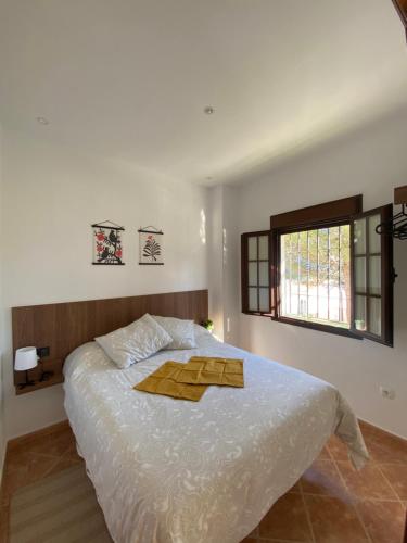 1 dormitorio con 1 cama blanca grande y cabecero de madera en EL MIRADOR, en Montejaque