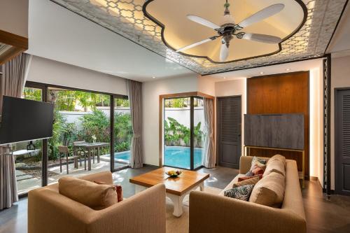 a living room with a couch and a ceiling fan at Dewa Phuket Resort & Villas, Nai Yang Beach in Nai Yang Beach