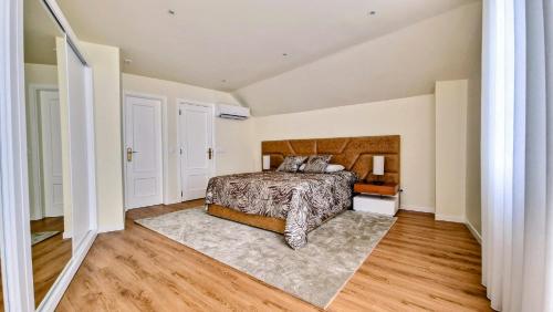 sypialnia z łóżkiem i drewnianą podłogą w obiekcie Apartamento Cava do Viriato Deluxe w mieście Viseu