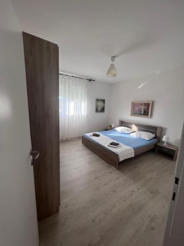 1 dormitorio con 1 cama y suelo de madera en Apartment Tea, en Rab
