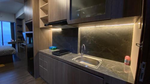 a kitchen with a sink and a counter top at Meisterstadt Pollux Habibie Apartment by uhomeid in Batam Center