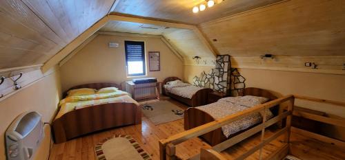 an attic room with three beds and a staircase at Biocinovici vikendica in Kolašin
