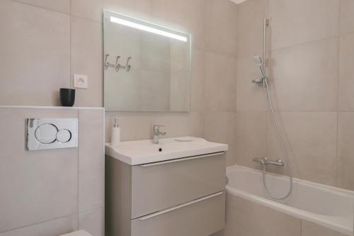 La salle de bains blanche est pourvue d'un lavabo et d'une douche. dans l'établissement ROOFTOP DE LA PLAGE Charming apartment on seafront with superb roof terrace, à Cannes